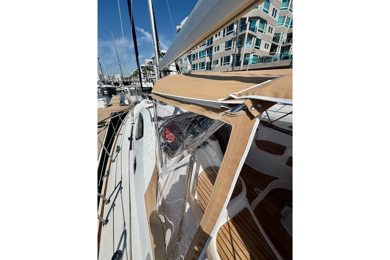 Slide: The Image of 2007 Jeanneau Sun Odyssey 42 DS sailboat docked at marina, featuring tan canopy and wooden deck. - 14