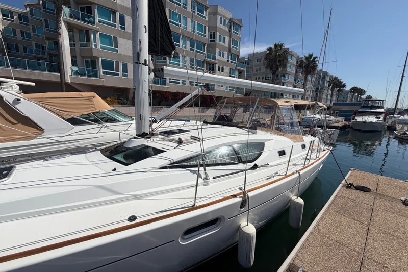 Slide: The Image of 2007 Jeanneau Sun Odyssey 42 DS sailboat docked at marina with modern buildings. - 18