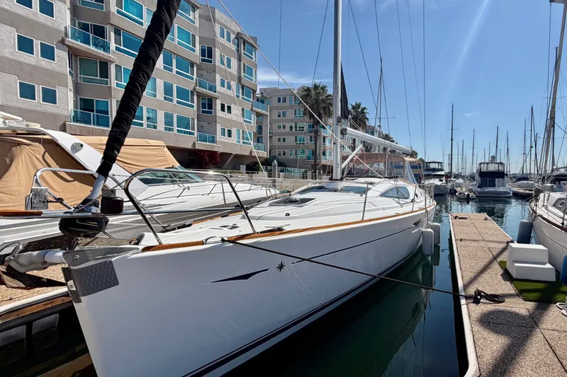 Slide: The Image of 2007 Jeanneau Sun Odyssey 42 DS sailboat docked in a marina, with modern buildings nearby. - 2