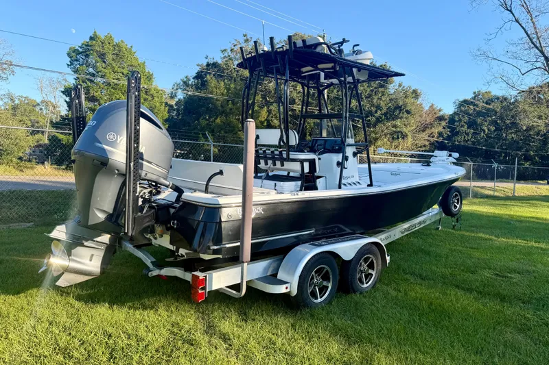 Slide: The Image of 2012 BlackJack 224 boat on trailer with Yamaha outboard motor, parked on grass. - 2