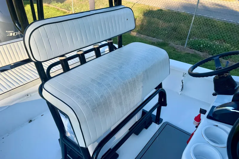 Slide: The Image of White seating on a 2012 BlackJack 224 boat, featuring a steering wheel and cup holders. - 9