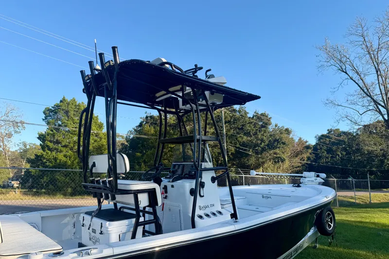 Slide: The Image of 2012 BlackJack 224 boat with elevated seating and canopy, set against a clear blue sky. - 11