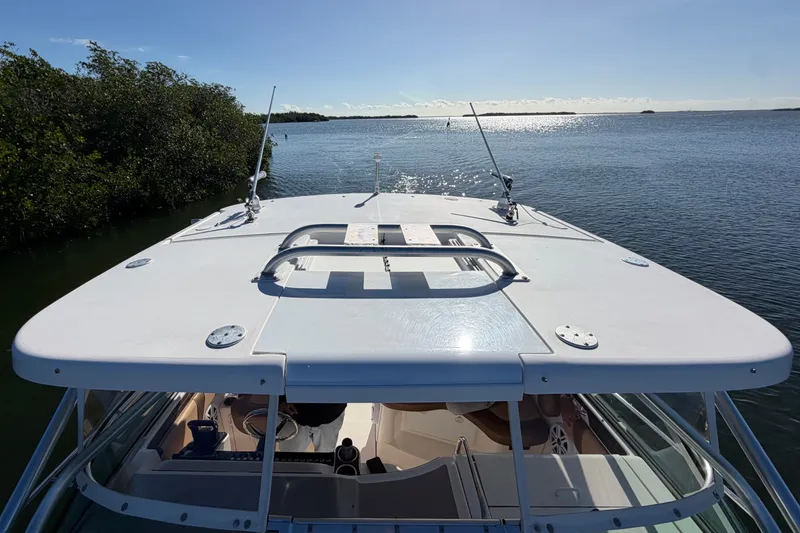 Slide: The Image of 2005 Wellcraft 290 Coastal boat on calm water, sunny day, lush greenery nearby. - 52