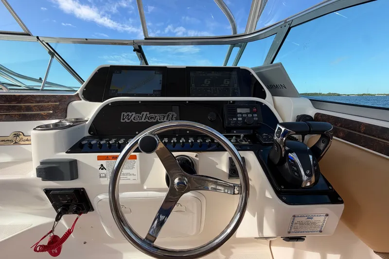 Slide: The Image of 2005 Wellcraft 290 Coastal helm with steering wheel, controls, and navigation screens. - 30
