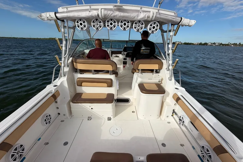 Slide: The Image of 2005 Wellcraft 290 Coastal boat interior with two people, on calm water under blue sky. - 17