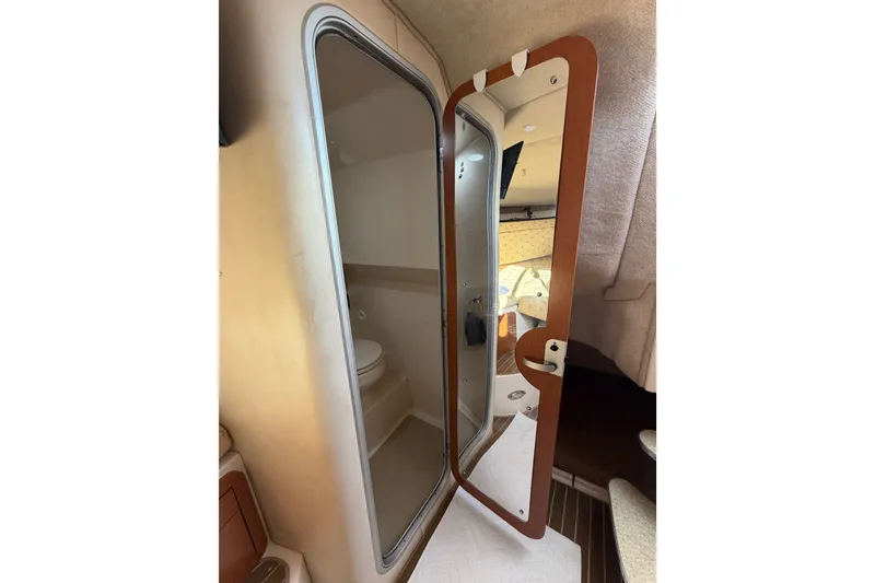 Slide: The Image of 2005 Wellcraft 290 Coastal cabin interior with open bathroom door, showcasing compact design. - 48