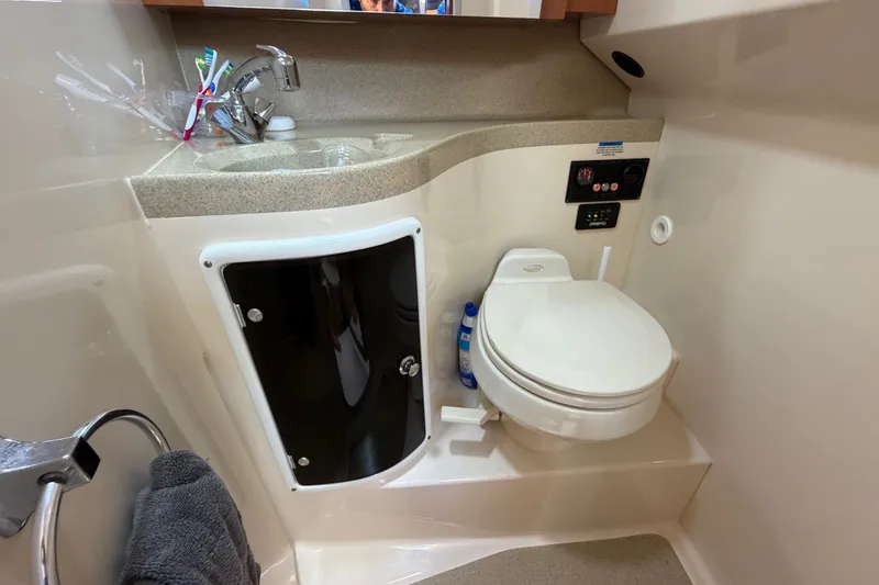 Slide: The Image of 2005 Wellcraft 290 Coastal boat bathroom with sink, toilet, and storage cabinet. - 46