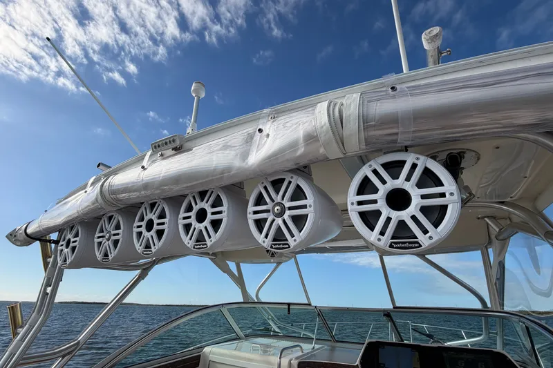 Slide: The Image of 2005 Wellcraft 290 Coastal boat with mounted Rockford Fosgate speakers under a clear blue sky. - 23