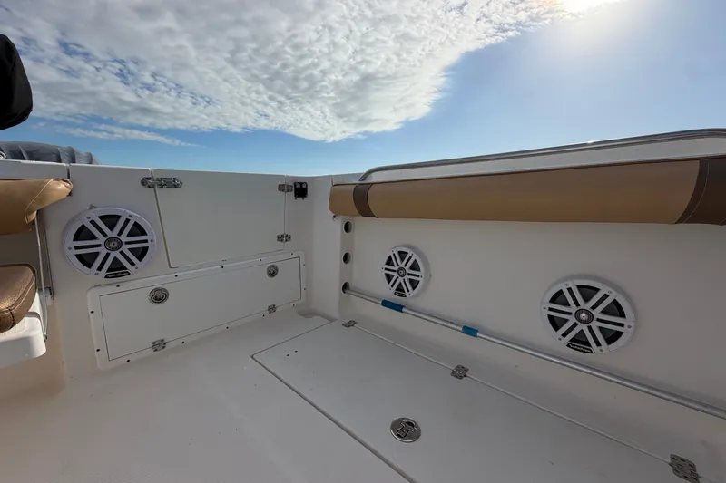 Slide: The Image of 2005 Wellcraft 290 Coastal boat interior with speakers and storage compartments under a cloudy sky. - 15
