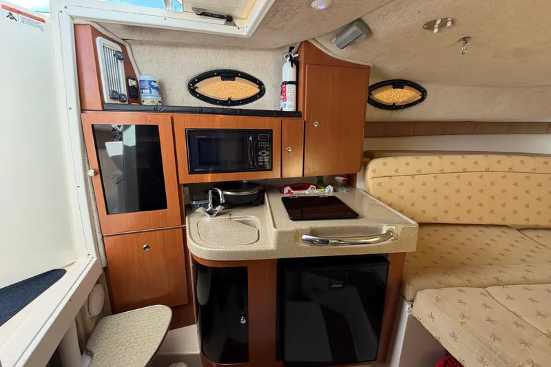 Slide: The Image of 2005 Wellcraft 290 Coastal boat interior with kitchenette, microwave, and seating area. - 37