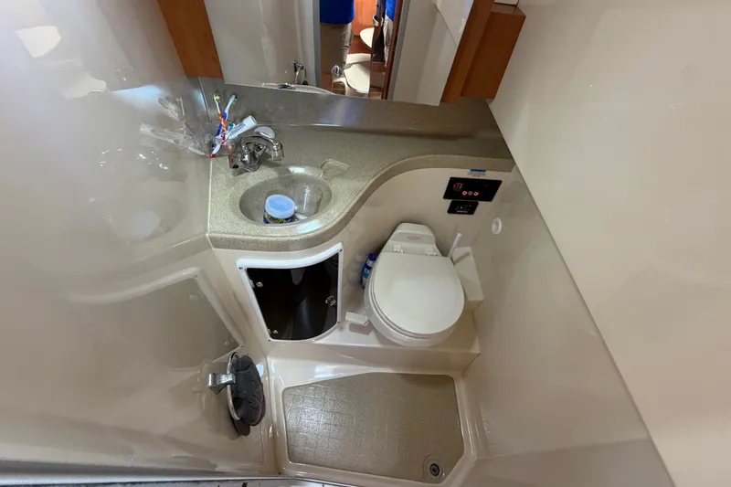 Slide: The Image of 2005 Wellcraft 290 Coastal boat bathroom with sink, toilet, and storage cabinet. - 47