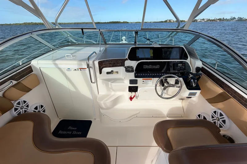 Slide: The Image of 2005 Wellcraft 290 Coastal boat cockpit with steering wheel and navigation controls. - 26