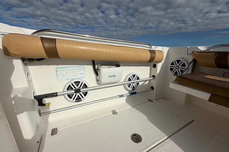 Slide: The Image of 2005 Wellcraft 290 Coastal boat interior with speakers and cushioned seating under a cloudy sky. - 13