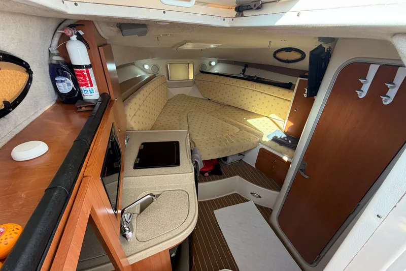 Slide: The Image of 2005 Wellcraft 290 Coastal cabin interior with kitchenette, seating, and storage. - 35