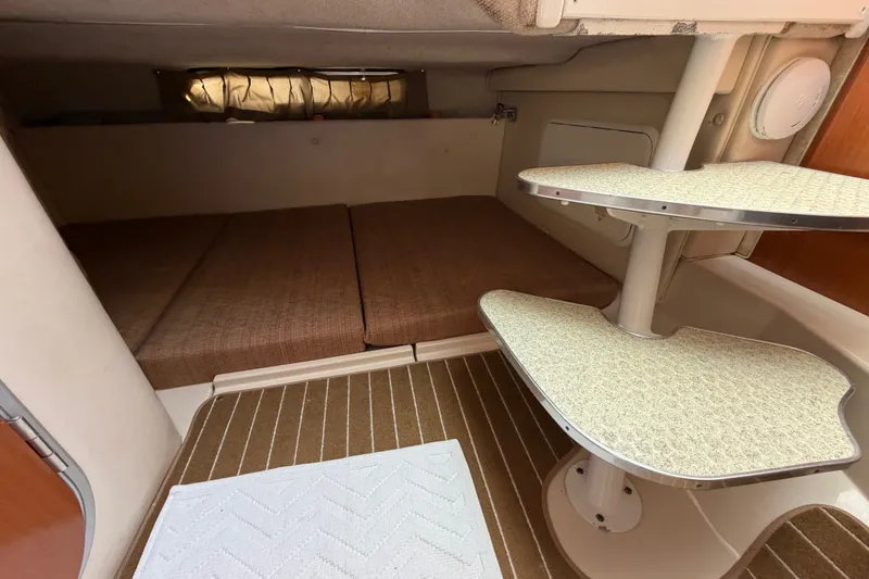 Slide: The Image of 2005 Wellcraft 290 Coastal cabin interior with brown cushions and compact table. - 44