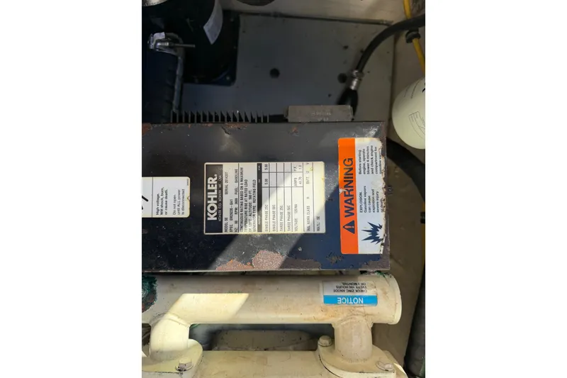 Slide: The Image of Engine compartment of 2005 Wellcraft 290 Coastal with Kohler generator and warning label. - 54