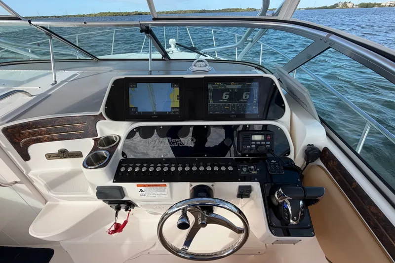 Slide: The Image of 2005 Wellcraft 290 Coastal boat helm with navigation screens and steering wheel on open water. - 27