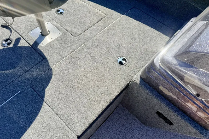 Slide: The Image of 2023 Ranger VS1665T boat interior with gray carpet and seating area. - 50