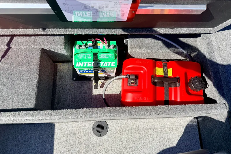 Slide: The Image of 2023 Ranger VS1665T boat battery and fuel tank compartment with Interstate battery and red fuel tank. - 24