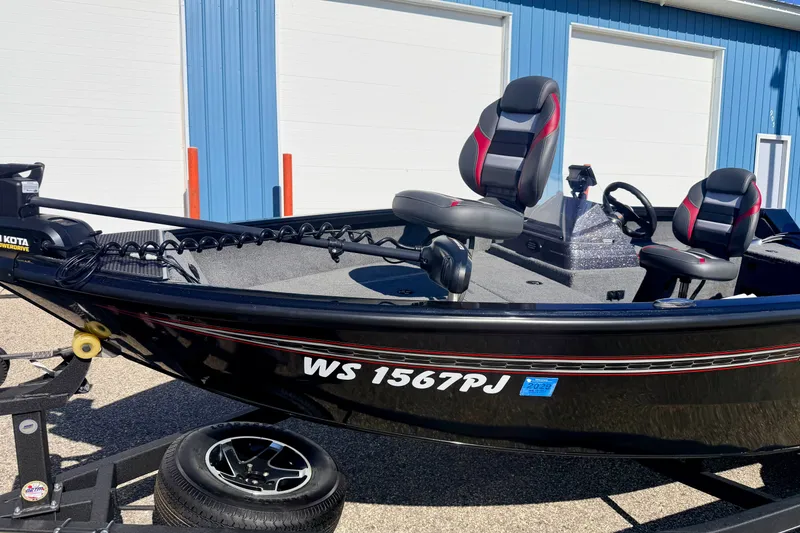 Slide: The Image of 2023 Ranger VS1665T boat with dual seats, parked on a trailer near blue building. - 10