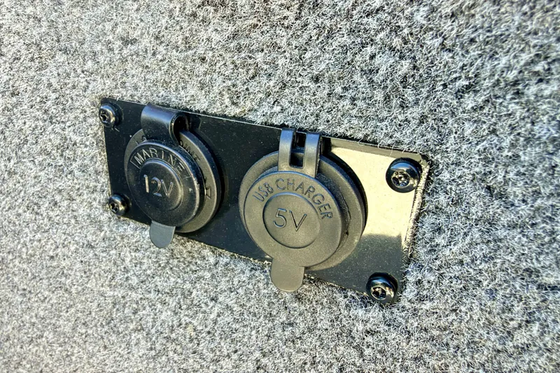 Slide: The Image of 2023 Ranger VS1665T marine 12V and USB 5V charger outlets on carpeted surface. - 64