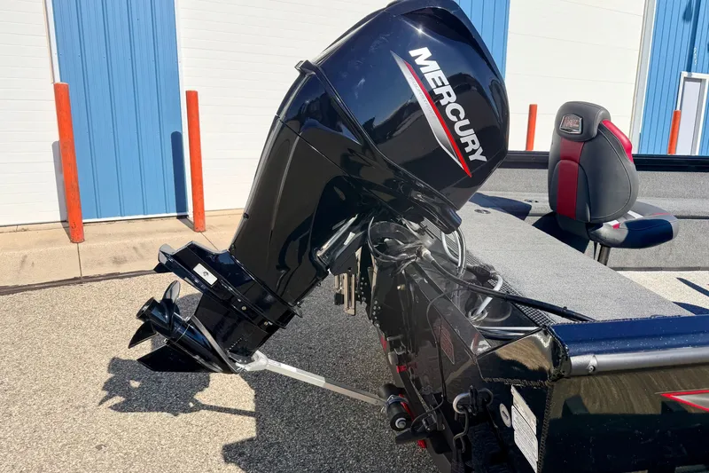 Slide: The Image of 2023 Ranger VS1665T boat with Mercury outboard motor, parked near blue and white building. - 17