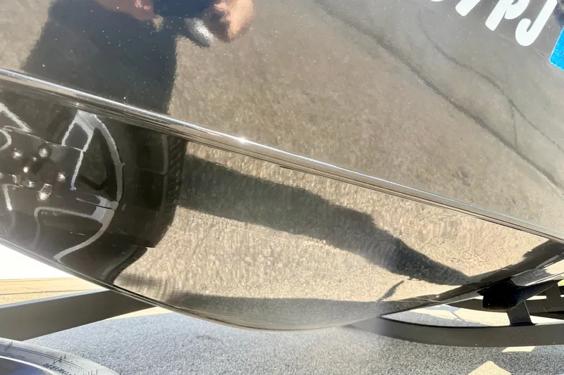 Slide: The Image of 2023 Ranger VS1665T boat hull with reflection and trailer wheel visible. - 77