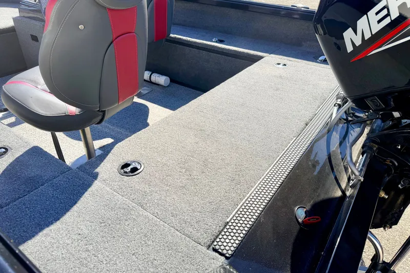 Slide: The Image of 2023 Ranger VS1665T boat interior with red and gray seating, carpeted flooring, and Mercury engine. - 22