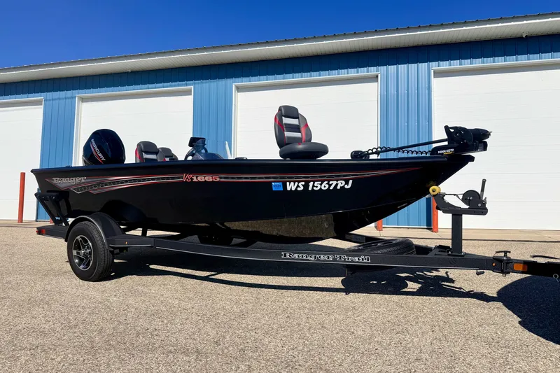 Slide: The Image of 2023 Ranger VS1665T boat on trailer, parked outside blue building. - 3