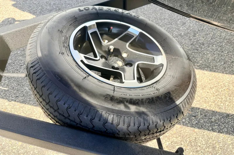 Slide: The Image of 2023 Ranger VS1665T trailer tire with alloy wheel on asphalt surface. - 69