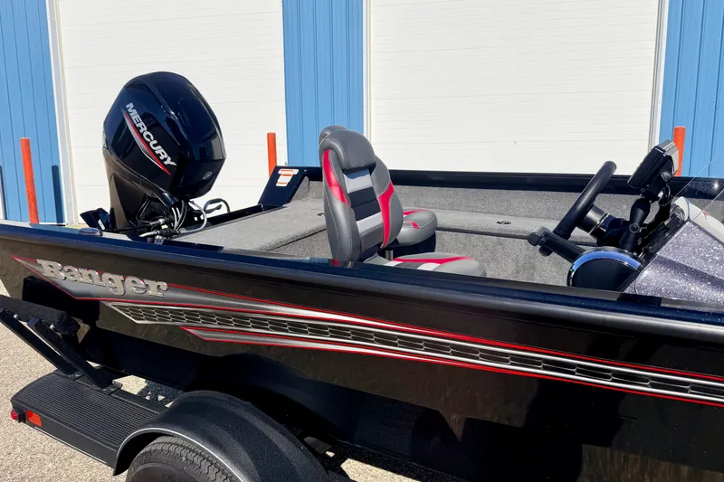 Slide: The Image of 2023 Ranger VS1665T boat with Mercury engine, black and red design, parked outdoors. - 15