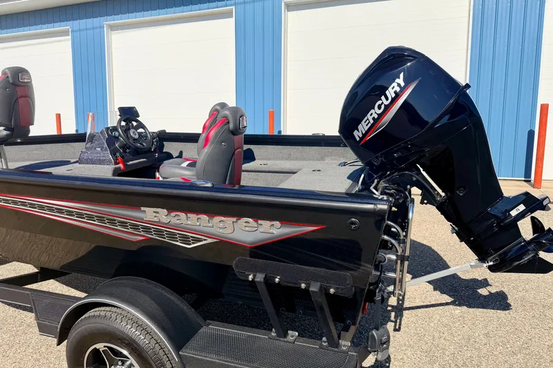 Slide: The Image of 2023 Ranger VS1665T boat with Mercury engine, parked outside blue building. - 11