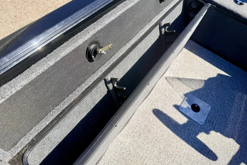 Slide: The Image of 2023 Ranger VS1665T boat interior storage compartment with key lock and carpeted flooring. - 31