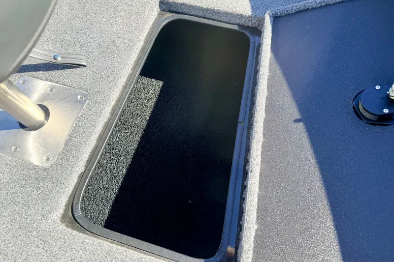 Slide: The Image of 2023 Ranger VS1665T boat storage compartment with carpeted interior and metal fittings. - 57