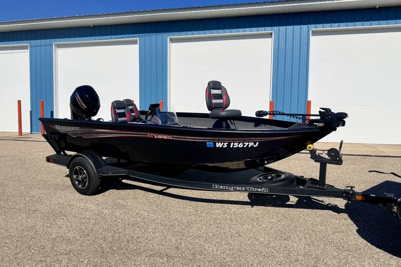 The Image of 2023 Ranger VS1665T boat on trailer, parked outside blue building. - 0