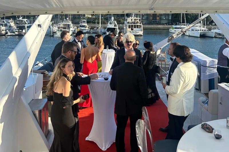 Slide: The Image of Elegant yacht party with guests in formal attire, red carpet, and marina backdrop. - 16