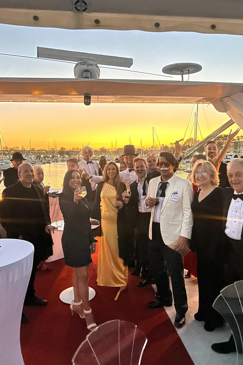 Slide: The Image of Group celebrating on a yacht at sunset, dressed in formal attire. - 15