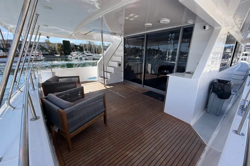 Slide: The Image of Luxurious yacht deck with wooden flooring, modern seating, and marina view, 1989 custom model. - 46