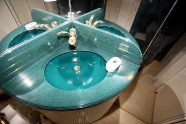 Slide: The Image of Teal bathroom sink with gold faucet, mirrored backsplash, and soap dish, custom design from 1989. - 27