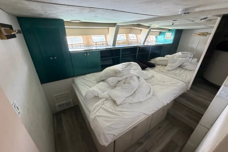 Slide: The Image of Cozy bedroom with unmade bed, teal cabinets, and multiple windows on a custom 1989 model. - 42