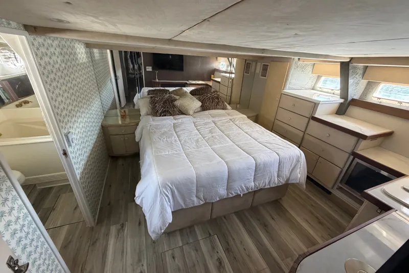 Slide: The Image of Cozy bedroom in a 1989 custom model, featuring a bed, pillows, and ample storage. - 43