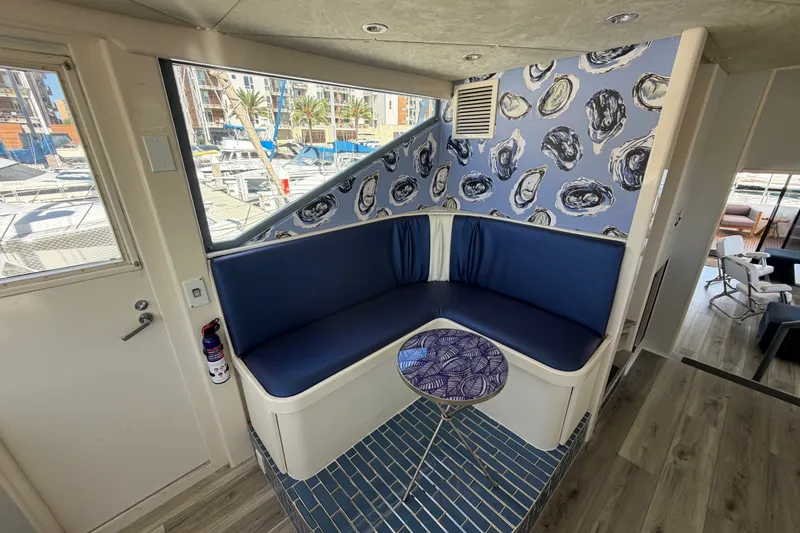 Slide: The Image of Cozy boat interior with blue seating, nautical wallpaper, and marina view through window. - 38