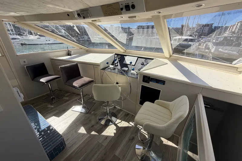 Slide: The Image of Interior of a 1989 custom boat with helm, chairs, and marina view. - 40