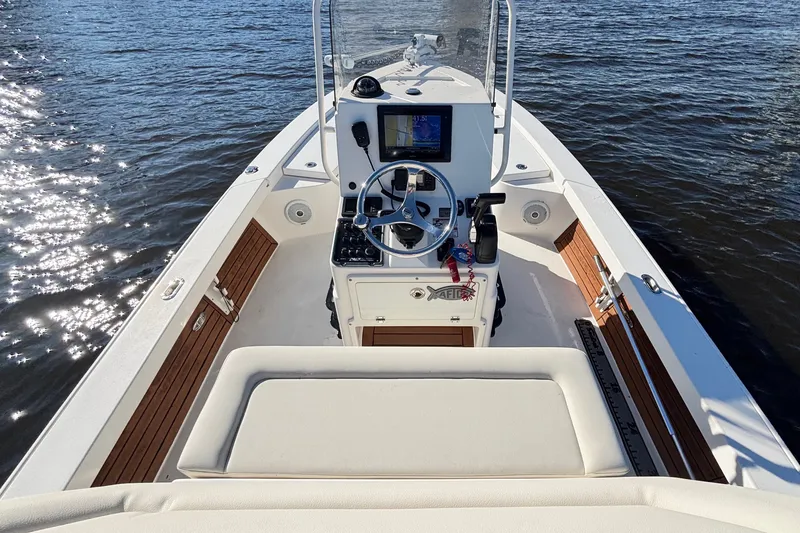 Slide: The Image of 2016 Pathfinder 2300 HPS boat interior with steering console on calm water. - 18