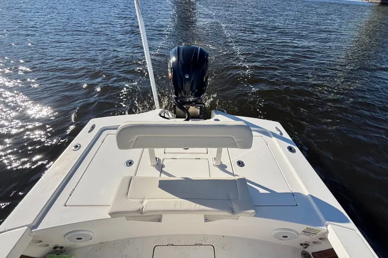 Slide: The Image of 2016 Pathfinder 2300 HPS boat cruising on a sunny day, rear view. - 20