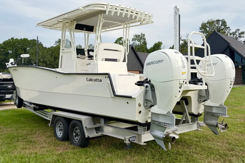 Slide: The Image of 2025 Calcutta 263 boat on trailer with dual Mercury engines, parked on grass. - 2