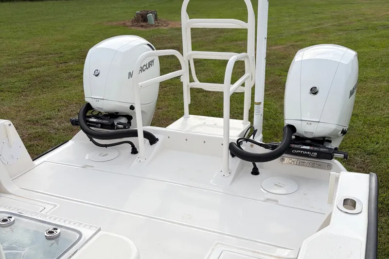 Slide: The Image of Twin Mercury outboard engines on a 2025 Calcutta 263 boat, parked on grass. - 6