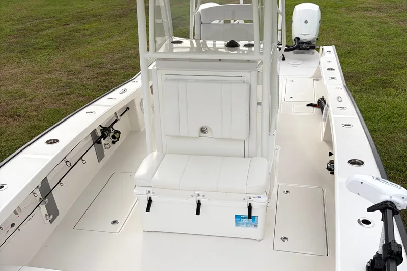 Slide: The Image of 2025 Calcutta 263 boat interior with seating, fishing rod holders, and motor on grassy background. - 9
