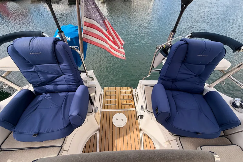 Slide: The Image of Two blue cushioned seats on a 2009 Hunter 33 yacht with American flag. - 25