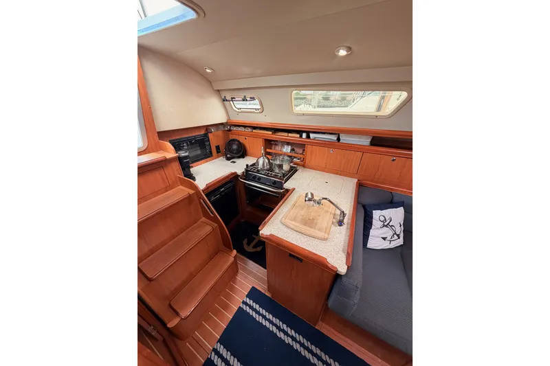 Slide: The Image of Interior of 2009 Hunter 33 sailboat with wooden cabinetry and compact kitchen area. - 37
